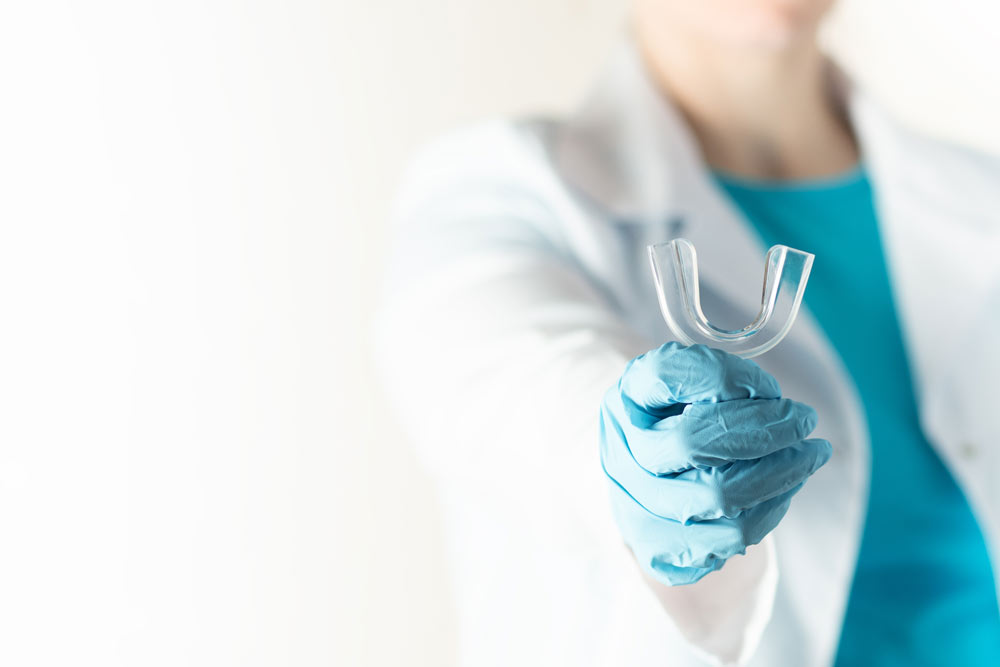 Tandläkare som håller i en bettskena