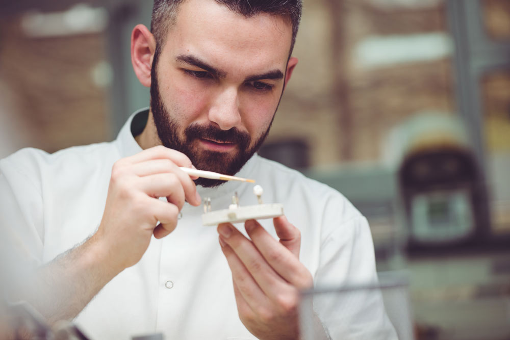 Tandläkare som håller i en tandkrona